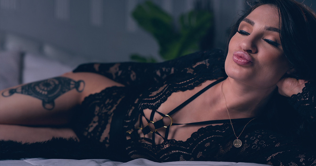 Woman posing confidently during a boudoir photoshoot, showing natural boudoir poses after preparing for the session.