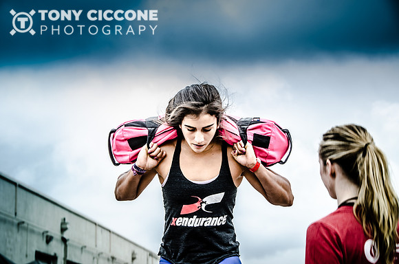 Crossfit female athlete Lauren Fisher doing step up with a sand bag