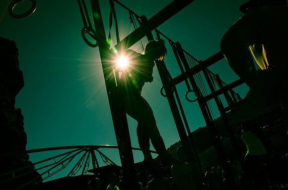 Crossfit girl doing a muscle up under the sun