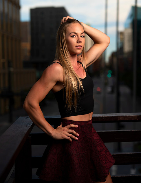 Fitness model posing in the city for an urban fitness photoshoot idea.
